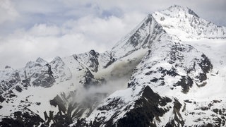 Staub von einem Felssturz steigt auf, an einer Flanke des Berges Bietschhorn im Lötschental, aufgenommen von der Ortschaft Wiler. Das Dorf Blatten im Lötschental musste wegen der Gefahr eines Felssturzes komplett evakuiert werden.