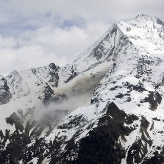 Staub von einem Felssturz steigt auf, an einer Flanke des Berges Bietschhorn im Lötschental, aufgenommen von der Ortschaft Wiler. Das Dorf Blatten im Lötschental musste wegen der Gefahr eines Felssturzes komplett evakuiert werden.