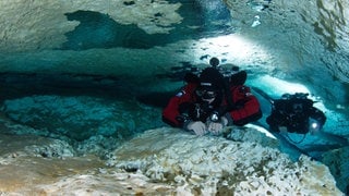 Florian Huber (links) und sein Kollege Christian Howe tauchen 2011 in dem undatierten Foto neben Jahrtausende alten Tropfsteinen in der Höhle „Cenote Las Calaveras“ in Mexiko.
