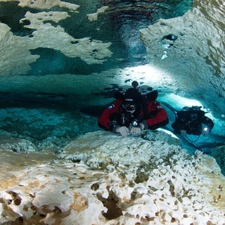 Florian Huber (links) und sein Kollege Christian Howe tauchen 2011 in dem undatierten Foto neben Jahrtausende alten Tropfsteinen in der Höhle „Cenote Las Calaveras“ in Mexiko.