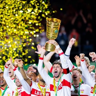 VfB Stuttgart gewinnt den DFB-Pokal gegen Arminia Bielefeld: Spieler reißen den Pokal in die Höhe - die Fans im Ausnahmezustand.