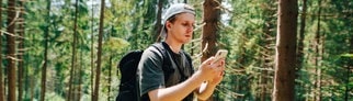 Mann im Wald sucht nach Handynetz: So kannst du helfen, das Mobilfunknetz in Deutschland zu verbessern