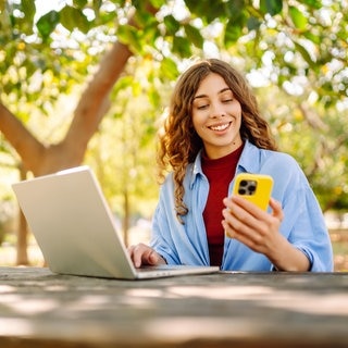 Eine Frau schaut auf ihr Smartphone. Das ändert sich im Juni.