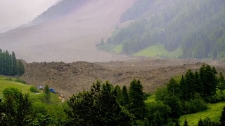 Eine große Lawine mit einem Gemisch aus Eis, Fels, Schnee und Wasser erreicht den Talboden in Wiler, nachdem der Birchgletscher oberhalb von Blatten, Schweiz, am Mittwoch, 28. Mai 2025, abgebrochen ist. 
