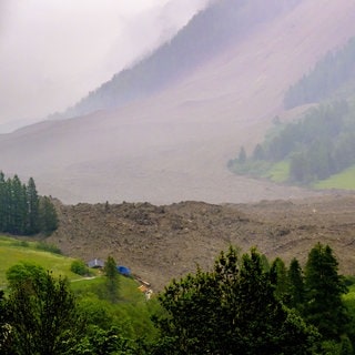 Eine große Lawine mit einem Gemisch aus Eis, Fels, Schnee und Wasser erreicht den Talboden in Wiler, nachdem der Birchgletscher oberhalb von Blatten, Schweiz, am Mittwoch, 28. Mai 2025, abgebrochen ist. 