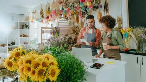 Ein Mann und eine Frau arbeiten in einem Blumengeschäft. Symbolbild für eine Studie, die zeigt, dass Menschen im gleichen Job oft ähnliche Persönlichkeiten haben.