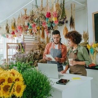 Ein Mann und eine Frau arbeiten in einem Blumengeschäft. Symbolbild für eine Studie, die zeigt, dass Menschen im gleichen Job oft ähnliche Persönlichkeiten haben.