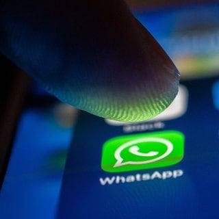 Ein Finger berührt das Whatsapp-Logo auf einem Smartphone. Bei Whatsapp gibt es jetzt einen neuen Chat mit Nachrichten von Whatsapp.