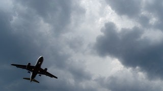 Gewitterwolken türmen sich über einem Flugzeug auf (Symbolbild). Ein Flugzeug musste wegen Unwetter zur Sicherheit in Memmingen landen.