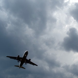 Gewitterwolken türmen sich über einem Flugzeug auf (Symbolbild). Ein Flugzeug musste wegen Unwetter zur Sicherheit in Memmingen landen.