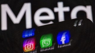 Die Apps Instagram, Facebook und WhatsApp sind auf dem Display eines Smartphones vor dem Logo des Internetkonzerns Meta zu sehen. Meta plant die Einführung von Werbung bei WhatsApp.