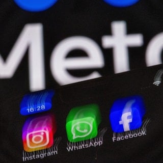 Die Apps Instagram, Facebook und WhatsApp sind auf dem Display eines Smartphones vor dem Logo des Internetkonzerns Meta zu sehen. Meta plant die Einführung von Werbung bei WhatsApp.