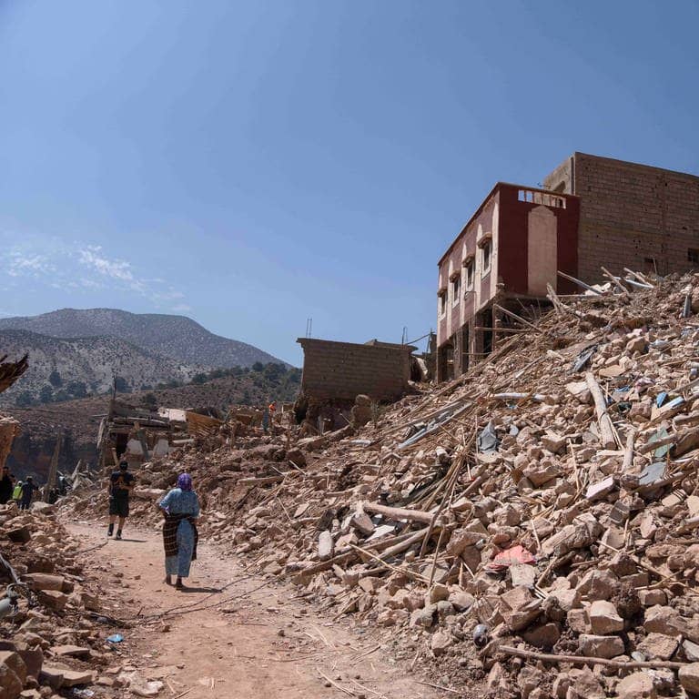 Menschen gehen an Trümmerhaufen vorbei, die das Erdbeben in Imi N'tala außerhalb von Marrakesch verursacht hat.