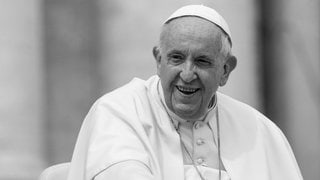 Papst Franziskus lächelt, während er im Papamobil über den Petersplatz in Rom fährt.