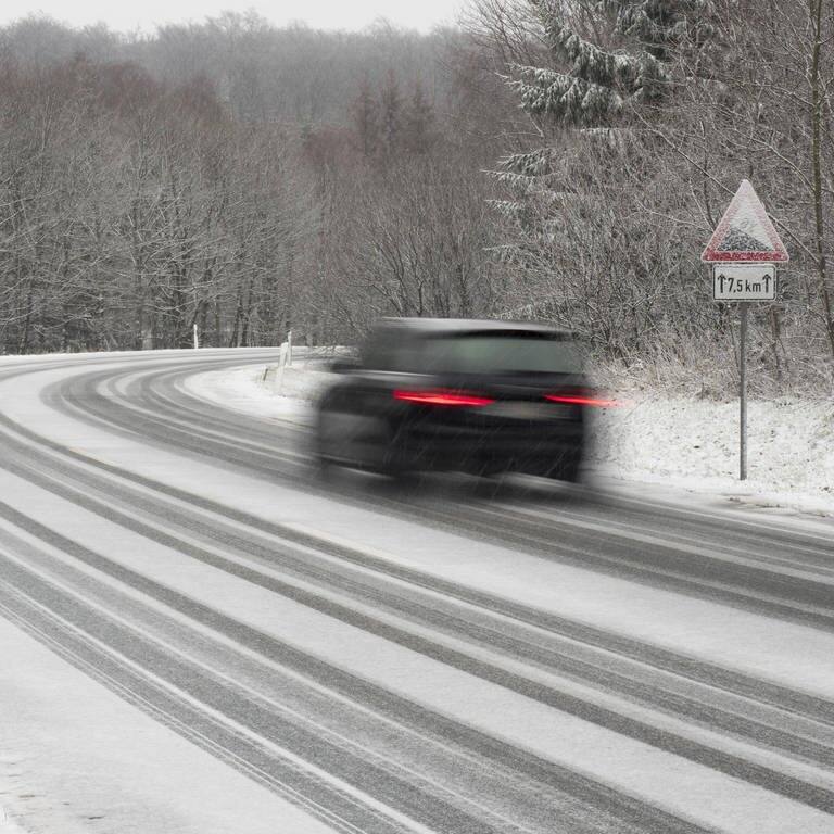 Ein Auto fährt auf einer Straße durch Schnee und Eis (Foto: IMAGO, IMAGO/imagebroker)
