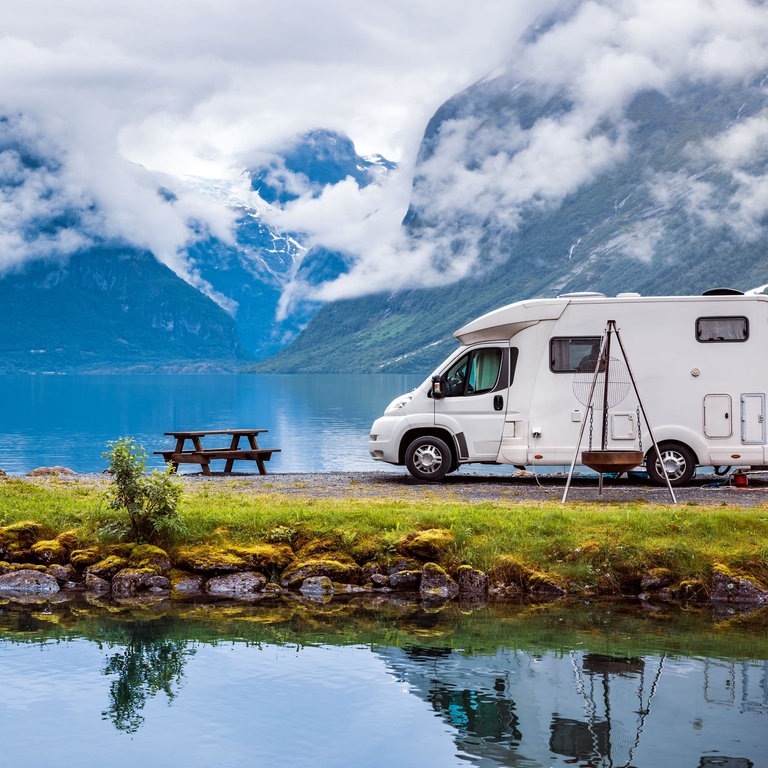 Wohnmobil vor Berg-Panorama an einem See (Foto: Adobe Stock/Gowtham)