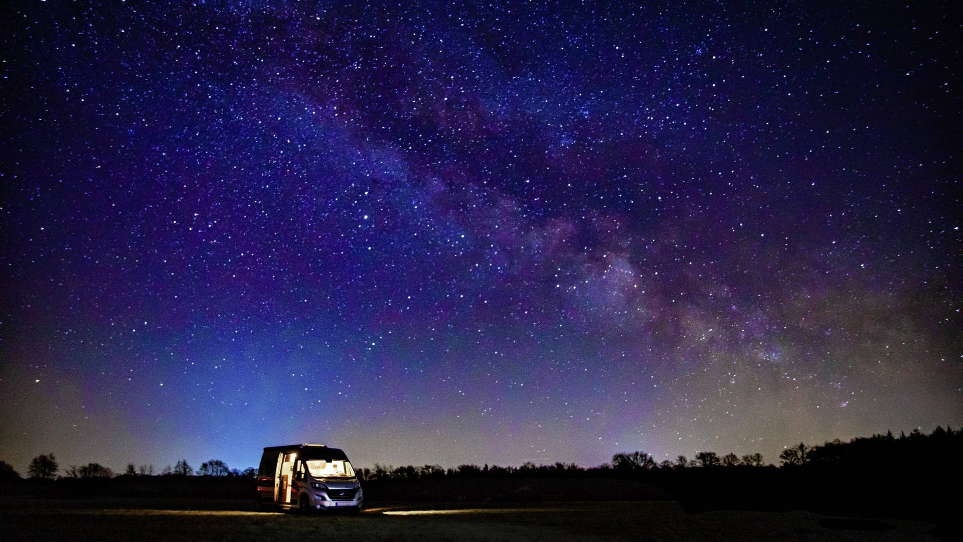 Wohnmobil steht unter einem Sternenhimmel (Foto: Adobe Stock/Melanie)
