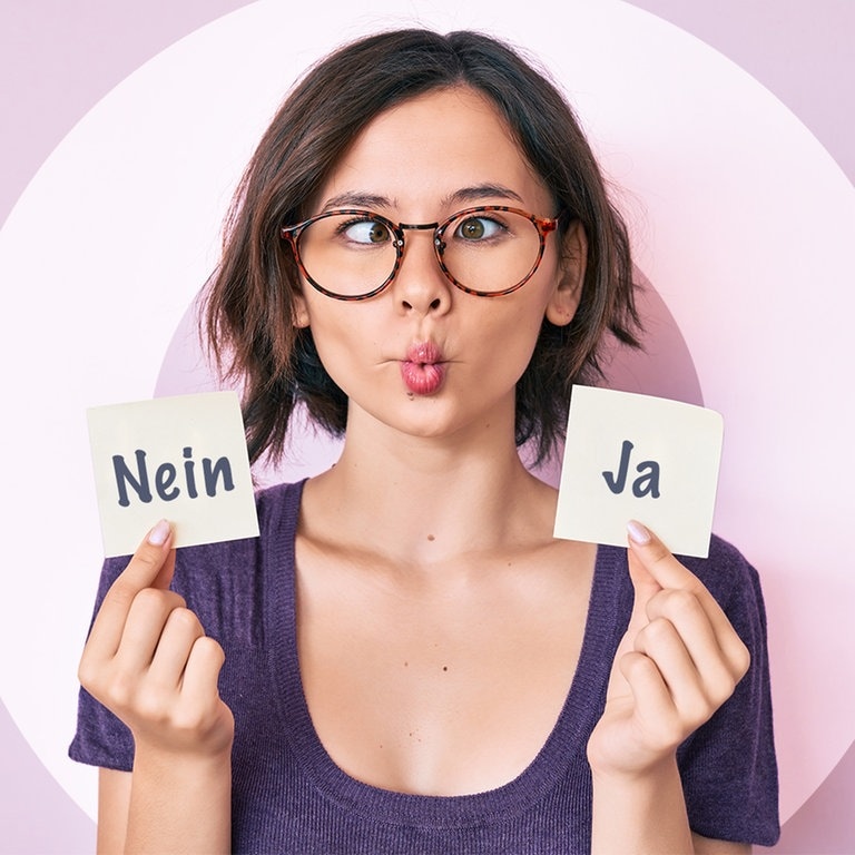 Frau zieht eine Grimasse, sie hält zwei Zettel in der Hand. Auf einem steht NEIN, auf einem JA. (Foto: Adobe Stock/Krakenimages.com)
