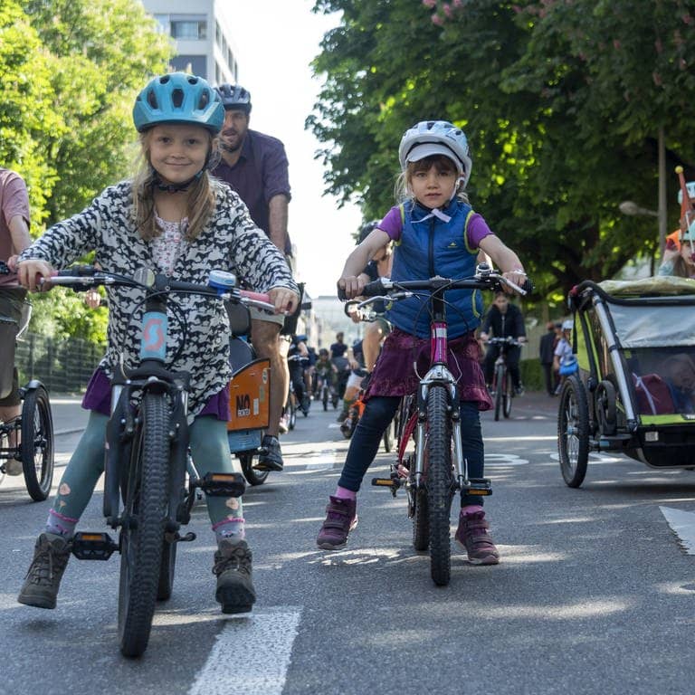 Kinder fahren mit ihren Eltern auf der Straße mit ihren Fahrrädern (Foto: picture-alliance / Reportdienste, picture alliance/KEYSTONE | GEORGIOS KEFALAS)