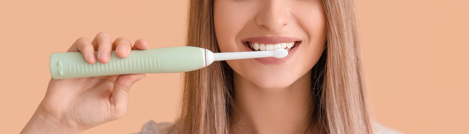 Frau putzt Zähne mit elektrischer Zahnbürste (Foto: Adobe Stock/Pixel Shot)