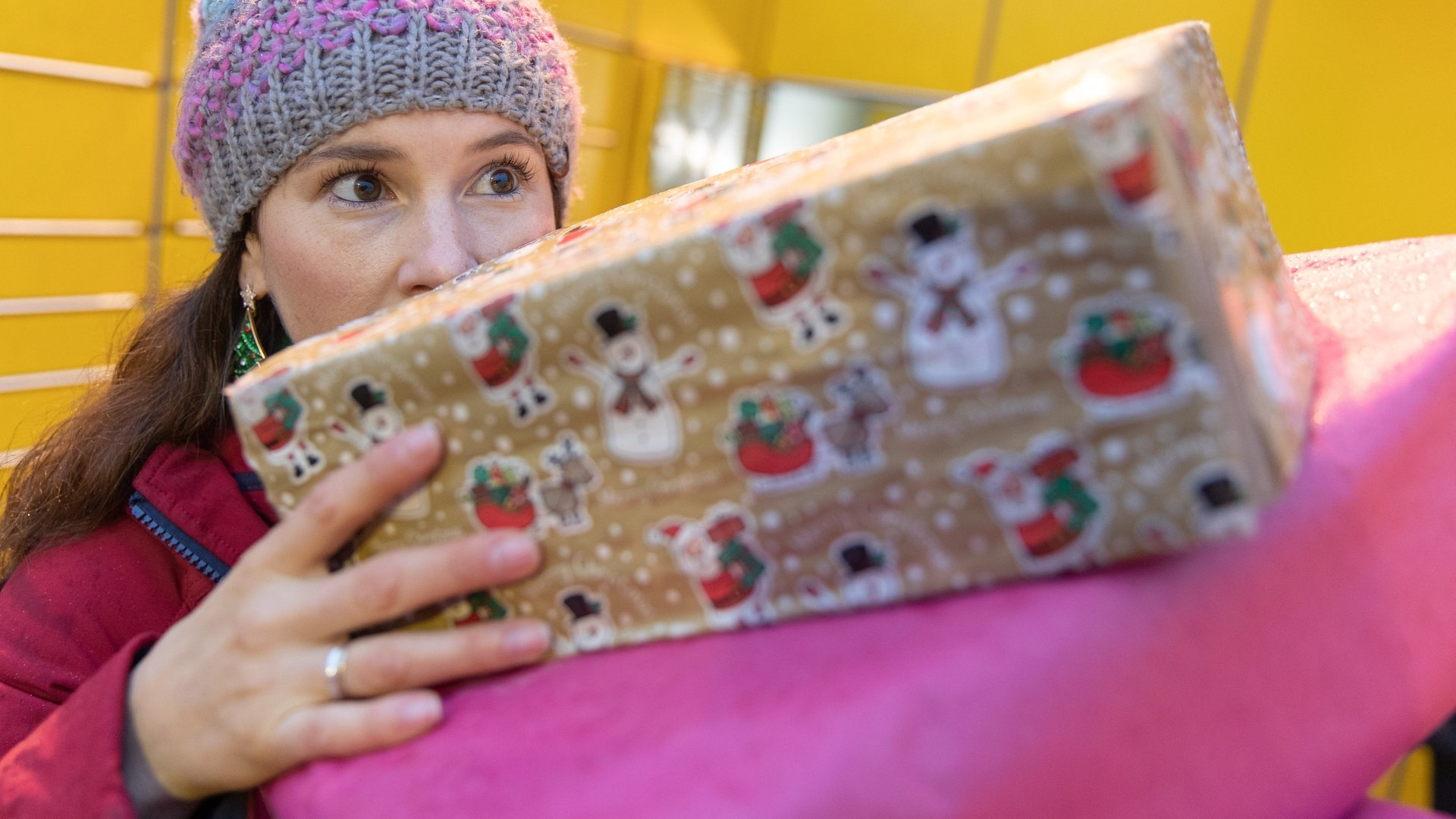 Eine Frau trägt ein paar Geschenke auf ihren Händen (Foto: dpa Bildfunk, Picture Alliance)