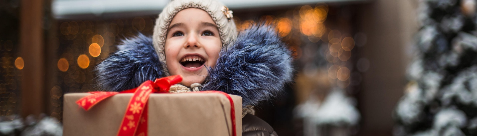Ein Kind freut sich über ein Geschenk (Foto: dpa Bildfunk, Picture Alliance)
