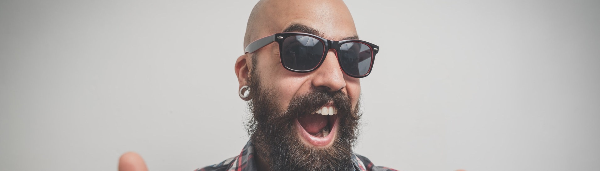 Mann mit Sonnenbrille, Bart und Glatze grinst in die Kamera und zeigt mit den Daumen nach oben (Foto: Adobe Stock/Eugenio Marongiu)
