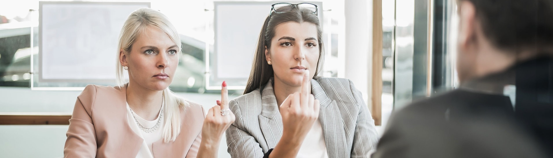 Zwei Frauen zeigen ihrem Chef den Mittelfinger (Foto: Adobe Stock,  S.Kobold)