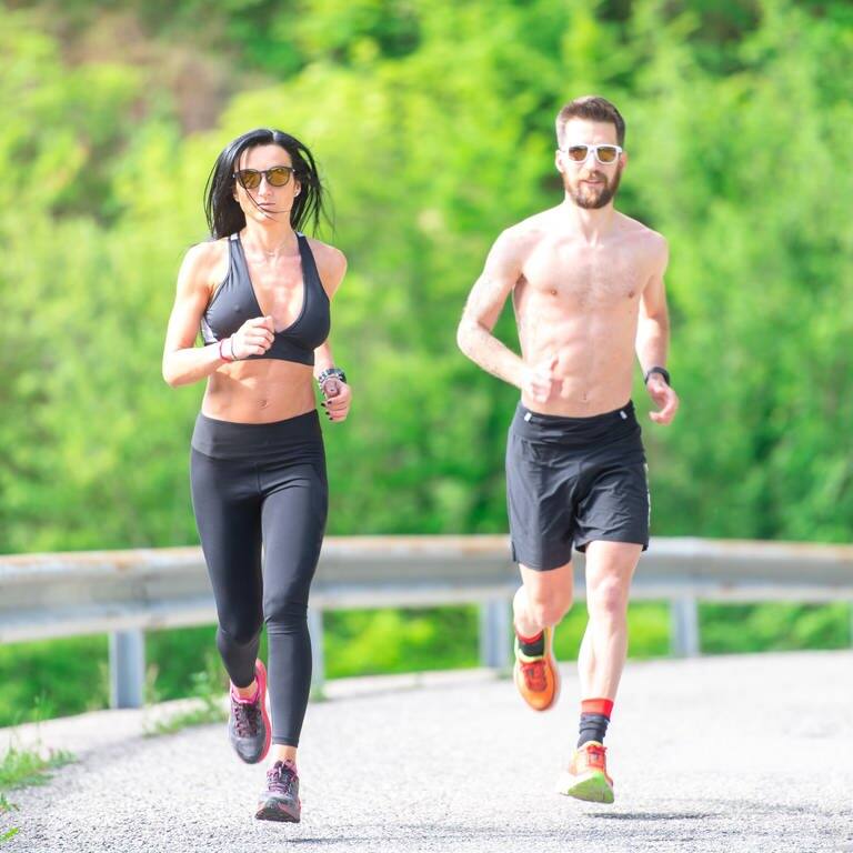 Ein Mann und eine Frau in Sportbekleidung joggen eine Straße entlang der Kamera entgegen. (Foto: picture-alliance / Reportdienste, picture alliance / CHROMORANGE | Michelangelo Oprandi)