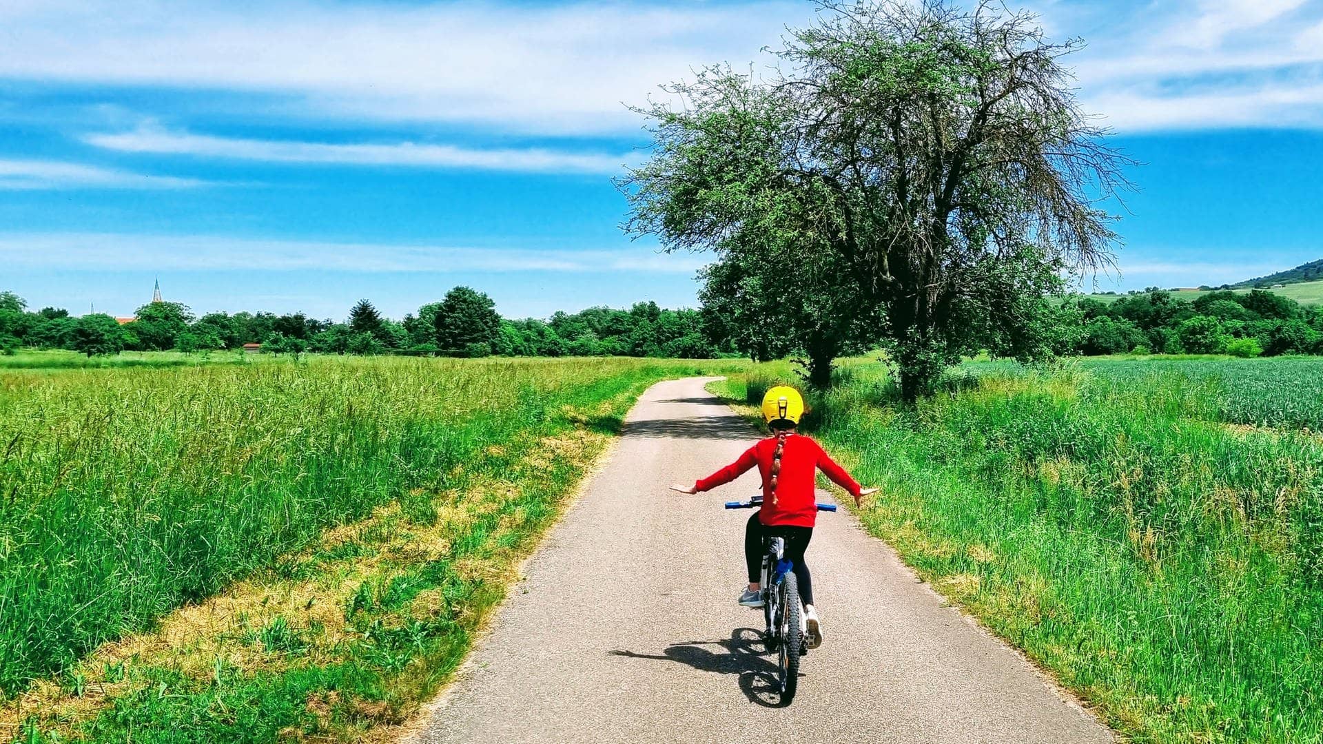 Ein Kind auf einem Fahrrad fährt auf einem Feldweg bei gutem Wetter (Foto: Stefan Scheurer)