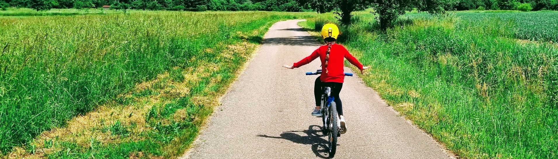 Ein Kind auf einem Fahrrad fährt auf einem Feldweg bei gutem Wetter (Foto: Stefan Scheurer)