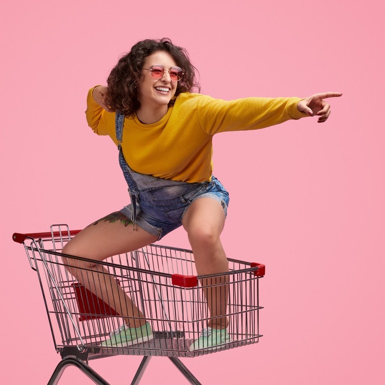 Frau steht in Einkaufswagen (Foto: Adobe Stock, kegfire)