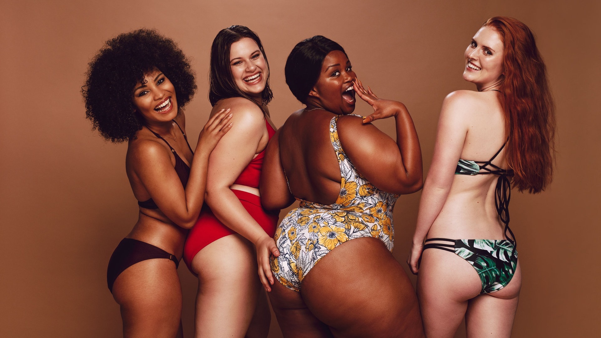 Vier Frauen mit unterschiedlichen Figuren und Hautfarben – lachend und selbstbewusst im Bikini (Foto: Adobe Stock, Jacob Lund)