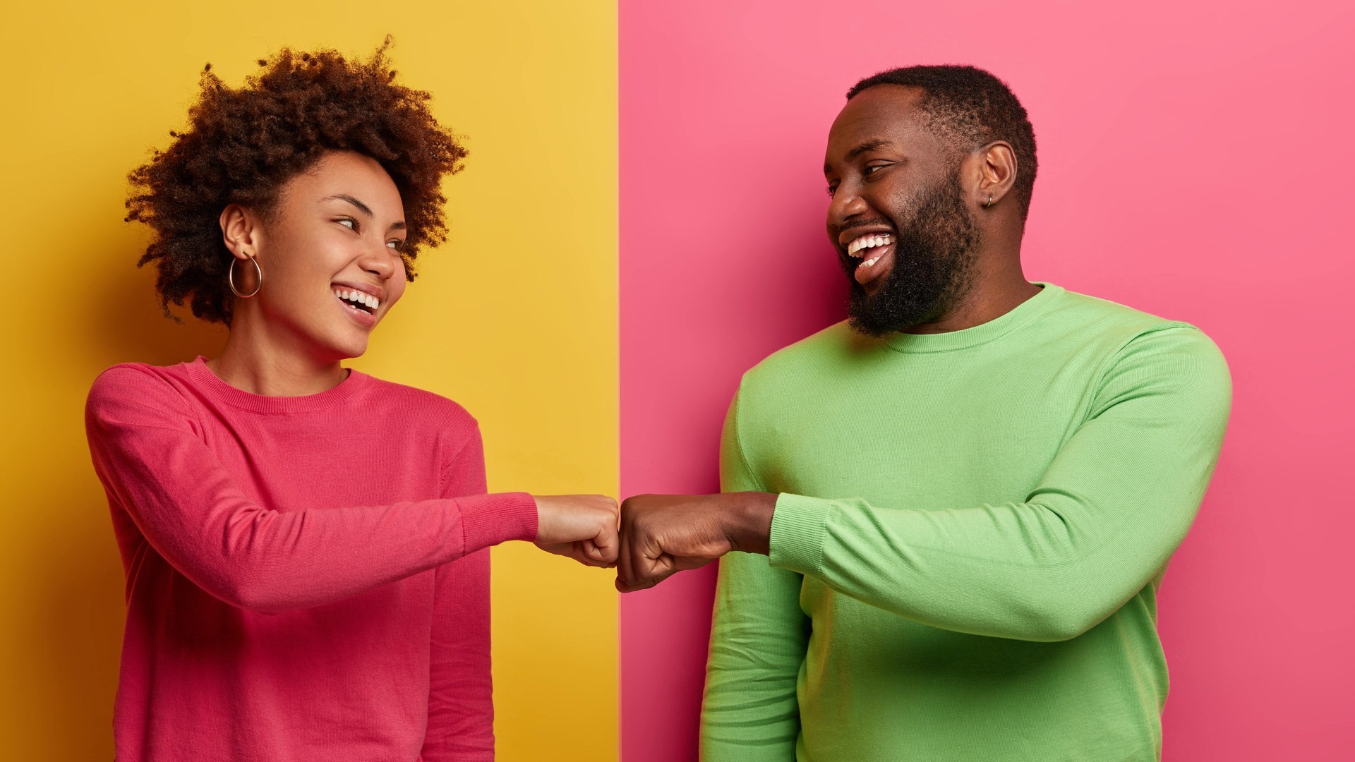 Foto: Adobe Stock, Wayhome Studio Junges Paar steht lachend vor einer durch zwei Farben getrennten Wand. Sie schlagen sie ab und sehen glücklich aus mit der Beziehung. (Foto: Adobe Stock, Wayhome Studio)