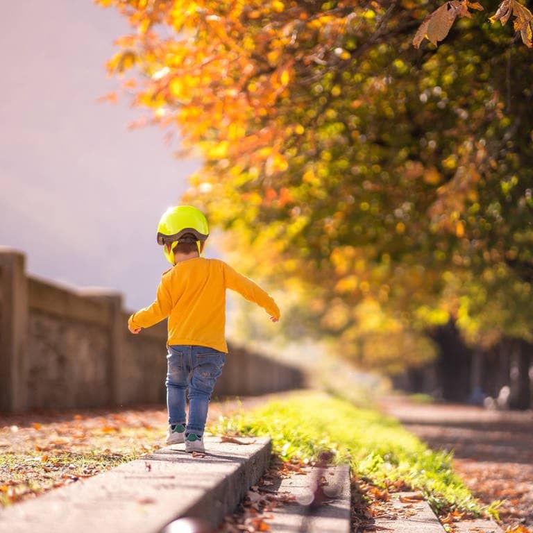 Junge spaziert im Herbst durch bunte Blätter (Foto: Adobe Stock, Addictive Stock)