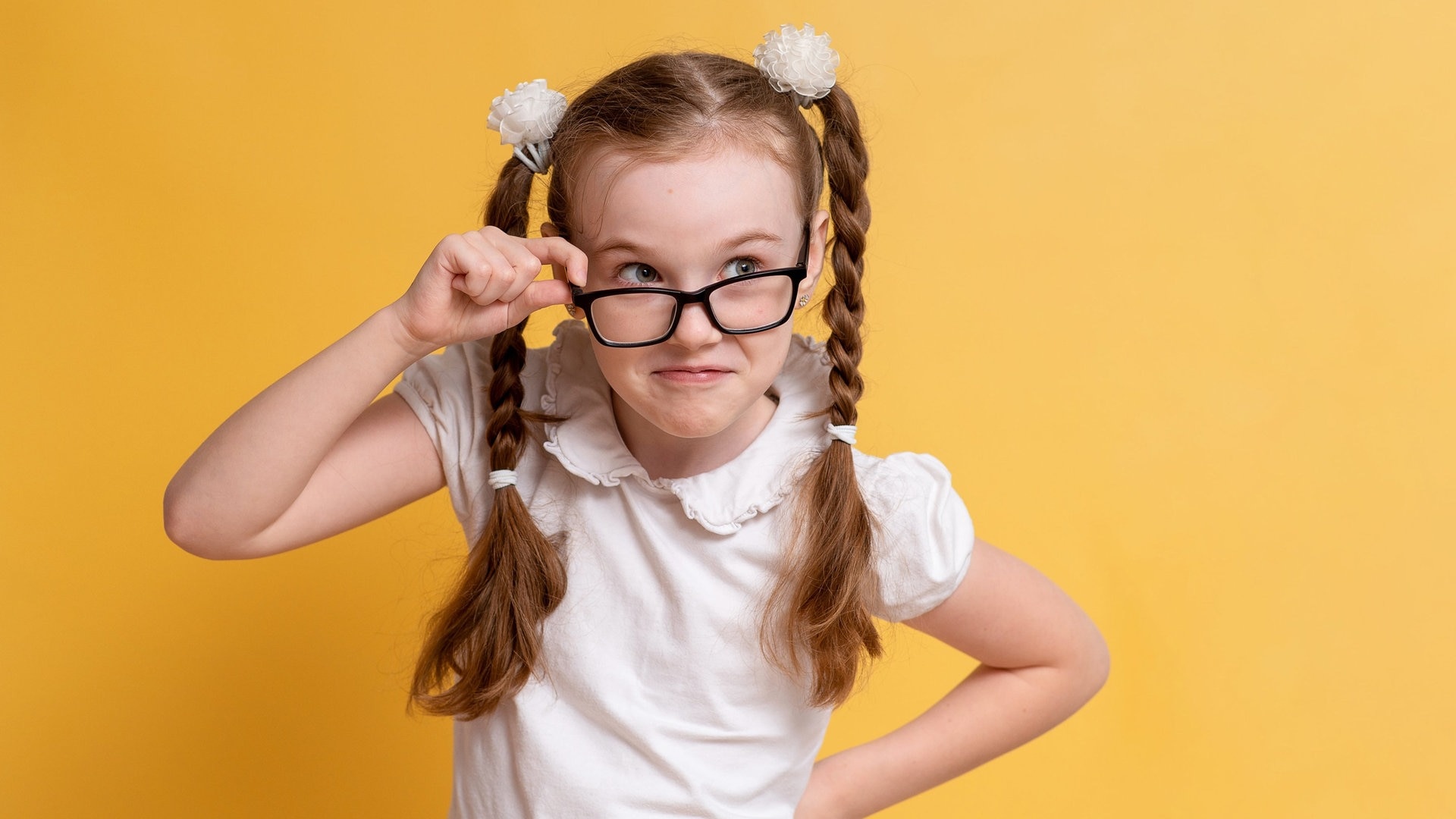 Mädchen mit Zöpfen und einer Brille sieht sehr schlau aus. Sie kennt sich vermutlich alle Eselsbrücken und Merksätze für die deutsche Rechtschreibung. (Foto: Adobe Stock, Katrin_Primak)