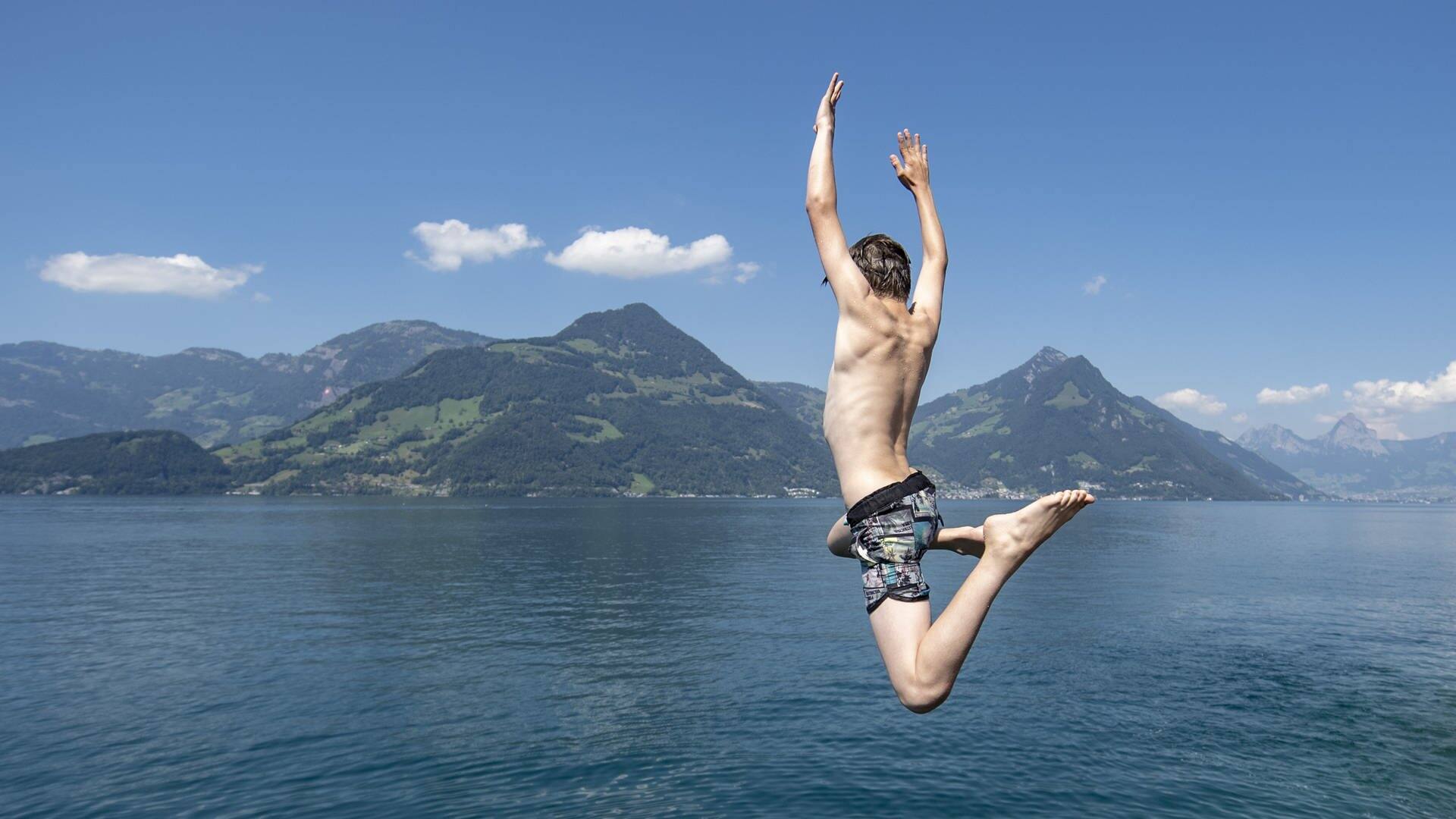 Jungs aus Beckenried im Kanton Nidwalden geniessen den tollen Sommertag mit einem Sprung in den Vierwaldstaettersee (Foto: picture-alliance / Reportdienste, picture alliance/KEYSTONE | URS FLUEELER)