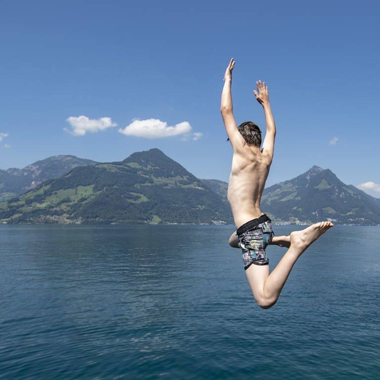 Jungs aus Beckenried im Kanton Nidwalden geniessen den tollen Sommertag mit einem Sprung in den Vierwaldstaettersee (Foto: picture-alliance / Reportdienste, picture alliance/KEYSTONE | URS FLUEELER)