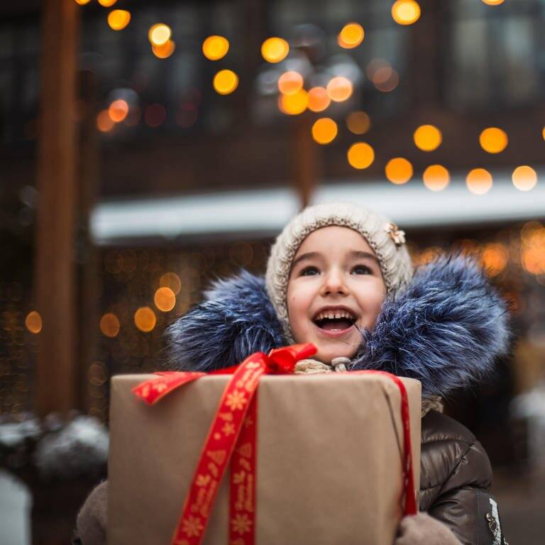 Tolle Geschenkideen: Ein Kind freut sich über ein Geschenk an Weihnachten. (Foto: dpa Bildfunk, Picture Alliance)