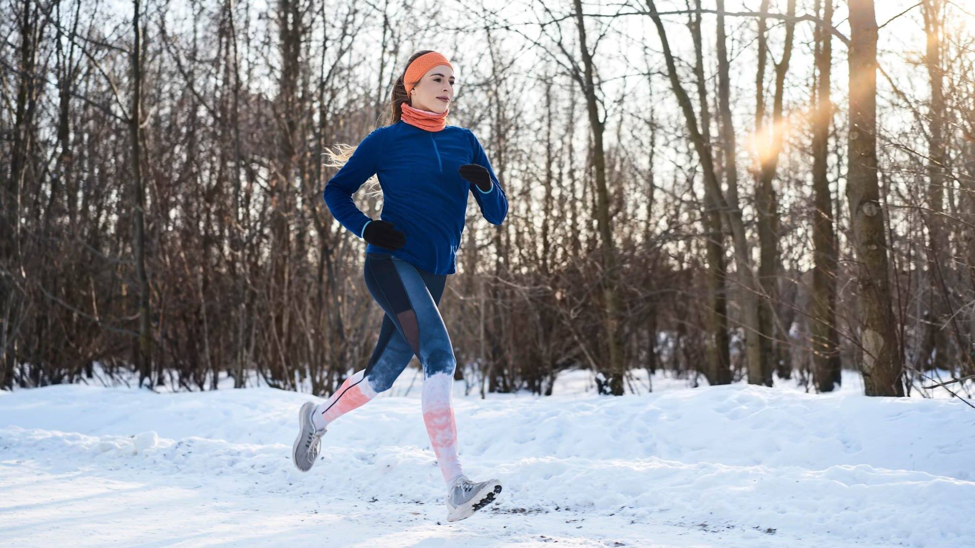 Junge Frau joggt im Winter durch den Schnee. Ein Mythos, der nicht stimmt: dass der Körper bei Kälte mehr Kalorien verbrennt. (Foto: Adobe Stock, Westend61)