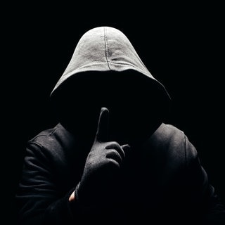 Eine dunkle Person, ohne Gesicht hält den Finger als Aufforderung zur Verschwiegenheit vor den Mund. Symbolbild für „Wie böse bin ich“-Selbsttest.