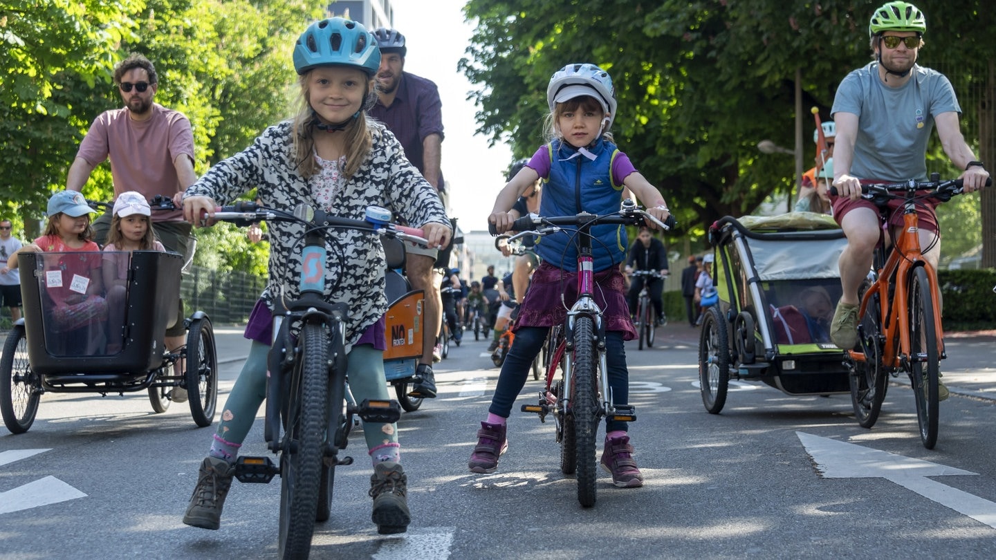 Kinder fahren mit ihren Eltern auf der Straße mit ihren Fahrrädern (Foto: picture-alliance / Reportdienste, picture alliance/KEYSTONE | GEORGIOS KEFALAS)