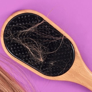 Blonde Haare in einer Haarbürste