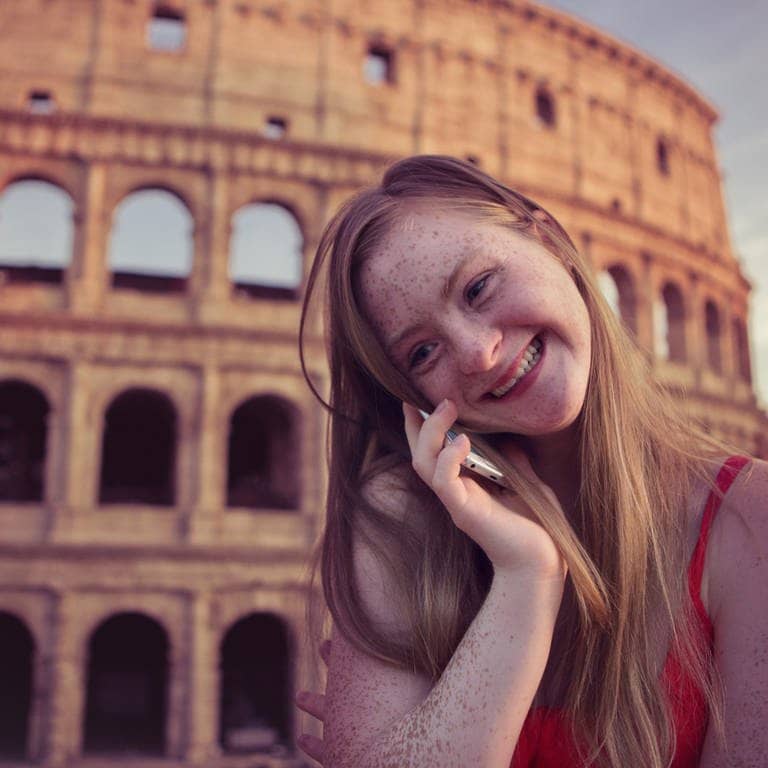 Das Tamara Röske vor dem Kolloseum in Rom telefoniert lächelnd mit einem Mobiltelefon.