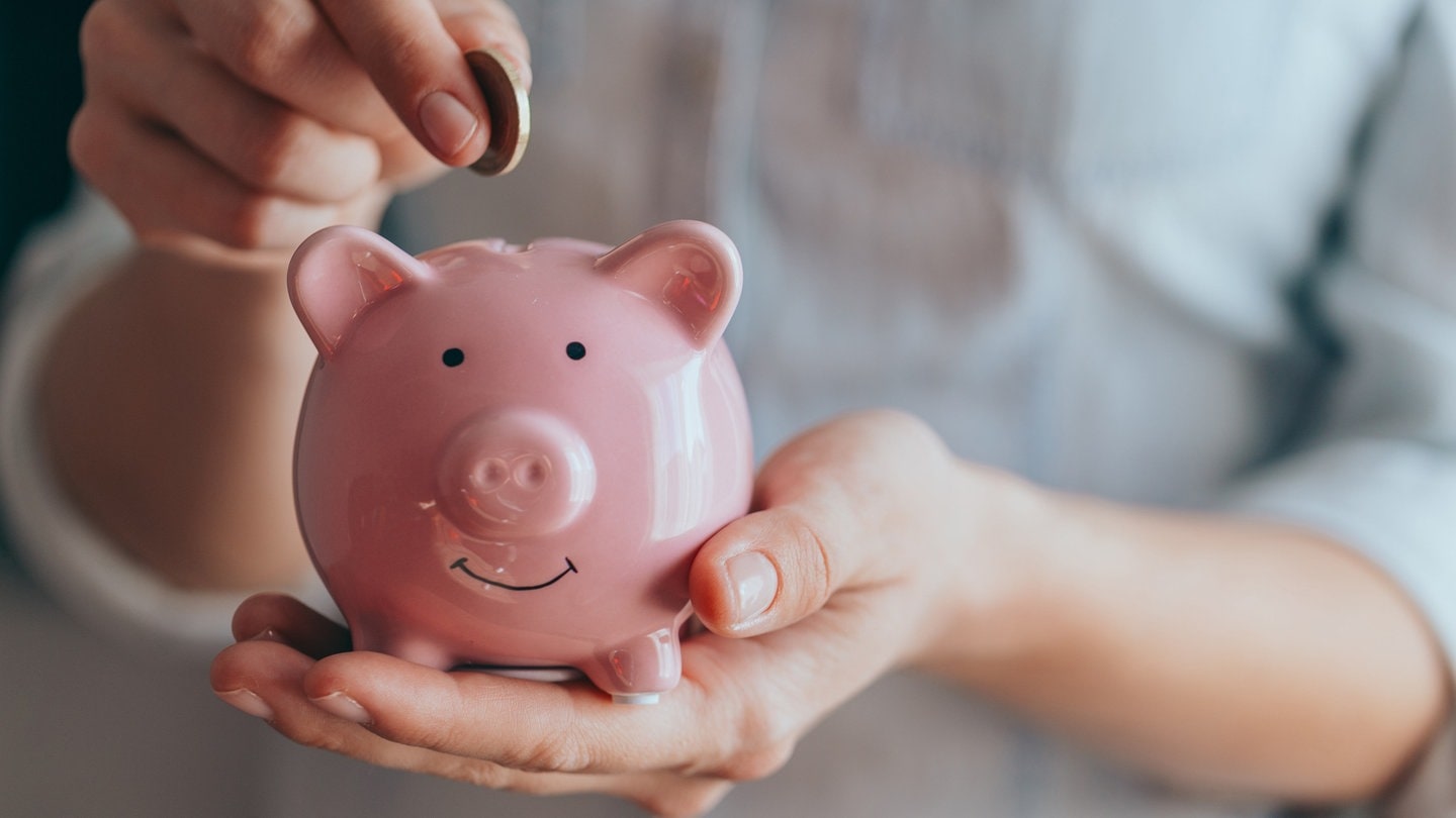 Ein Sparschwein schaut fröhlich in die Kamera. (Foto: Adobe Stock, Nana_studio)