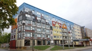 Ein Plattenbau in Gera, dessen Fassade mit einem Fachwerdorf bemalt ist. (Foto: Turit Fröbe) Ein Plattenbau in Gera, dessen Fassade mit einem Fachwerdorf bemalt ist.