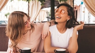 Zwei Freundinnen sitzen in einem Café, vor ihnen auf dem Tisch stehen die Getränke. Sie lachen gemeinsam, vielleicht über die Storys aus Partnerschaft und Liebe, die sie einander erzählen. (Foto: Adobe Stock, halayalex) Zwei Freundinnen sitzen in einem Café, vor ihnen auf dem Tisch stehen die Getränke. Sie lachen gemeinsam, vielleicht über die Storys aus Partnerschaft und Liebe, die sie einander erzählen.