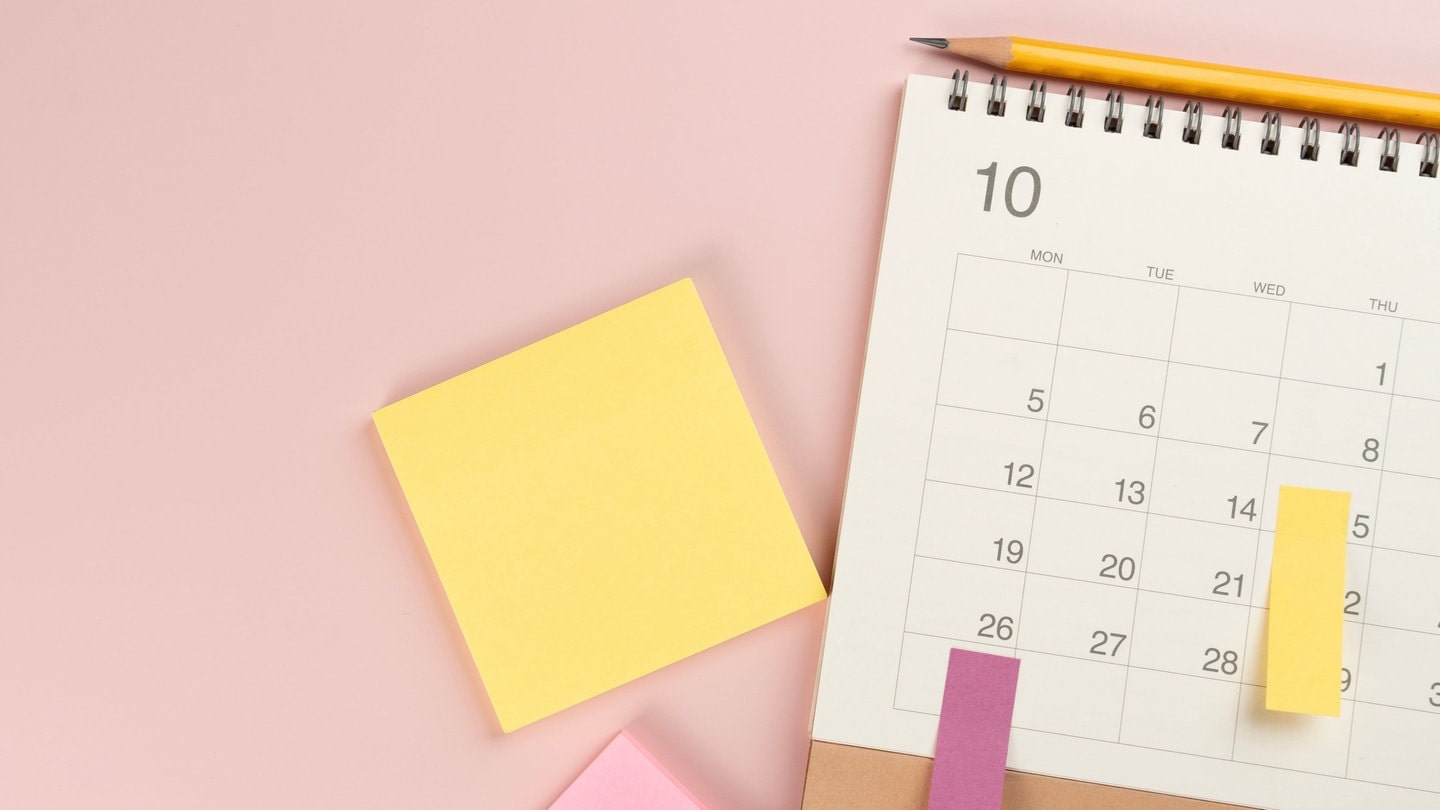 Urlaub fürs nächste Jahr planen – ein Kalender mit Post-it-Zetteln liegt auf dem Tisch. Mit den Feiertagen und Brückentagen die Möglichkeiten optimal nutzen. (Foto: Adobe Stock, tatomm)