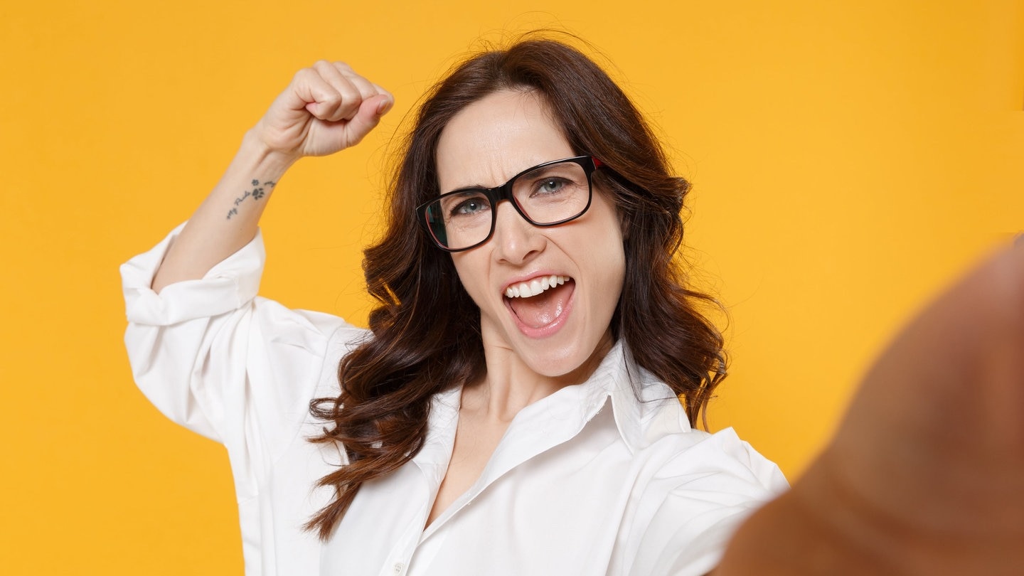 Junge Frau im Business-Outfit mit Bluse im Selfie-Look. Sie ist auf der Suche nach Tipps zur Beförderung und einem Aufstieg im Job. (Foto: Adobe Stock, ViDi Studio)