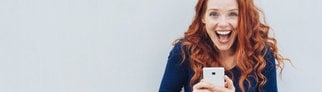 Junge Frau mit Smartphone in der Hand lacht über kuriose Redewendungen – wörtlich übersetzt von Deutsch auf Englisch, sehr schlecht – aber lustig.